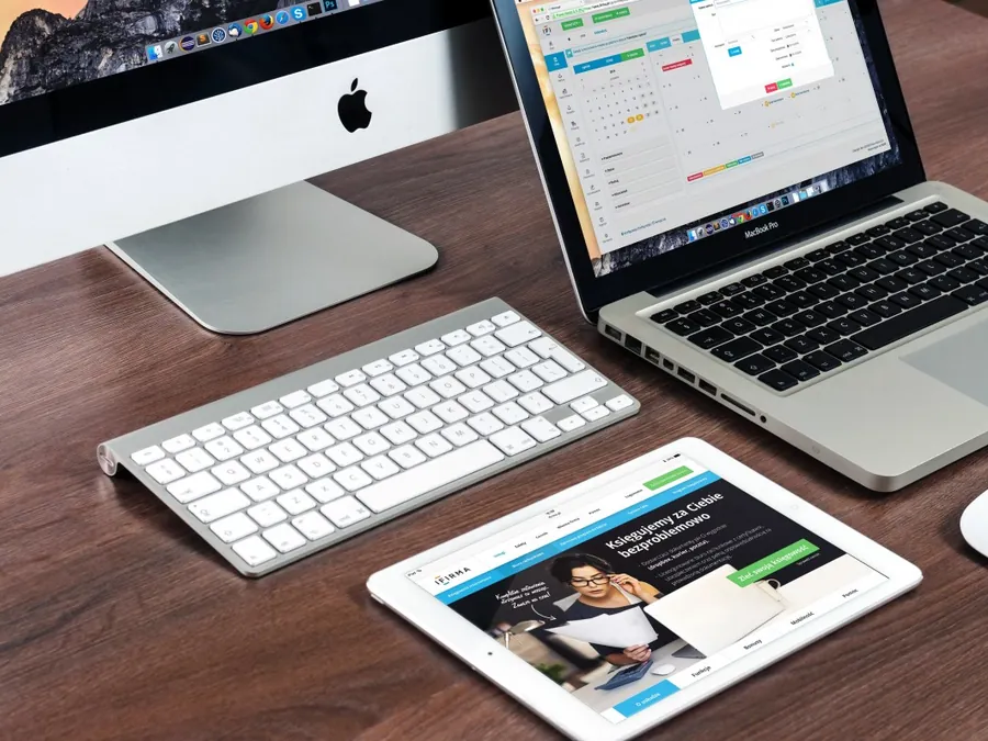 A desk with a desktop display, laptop and tablet all showing the same interface layout